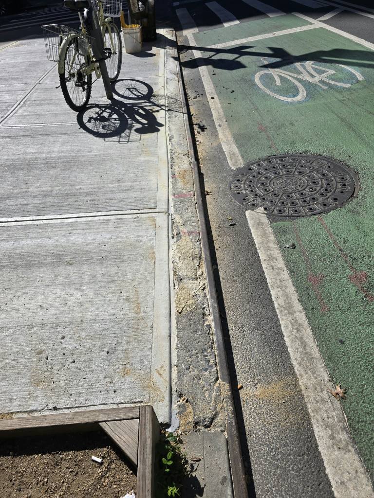 New sidewalk curb edge next to a bike lane after DOT violation repair on Second Avenue, Manhattan