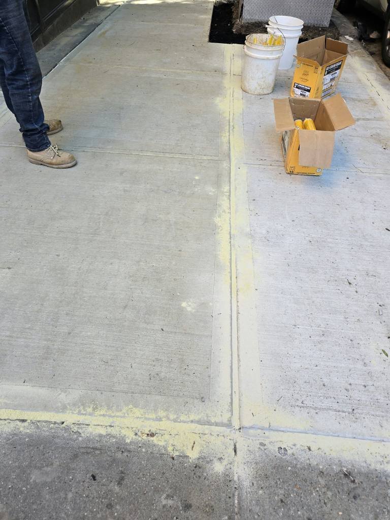 Control joint between new sidewalk flags after DOT violation repair on Second Avenue, Upper East Side